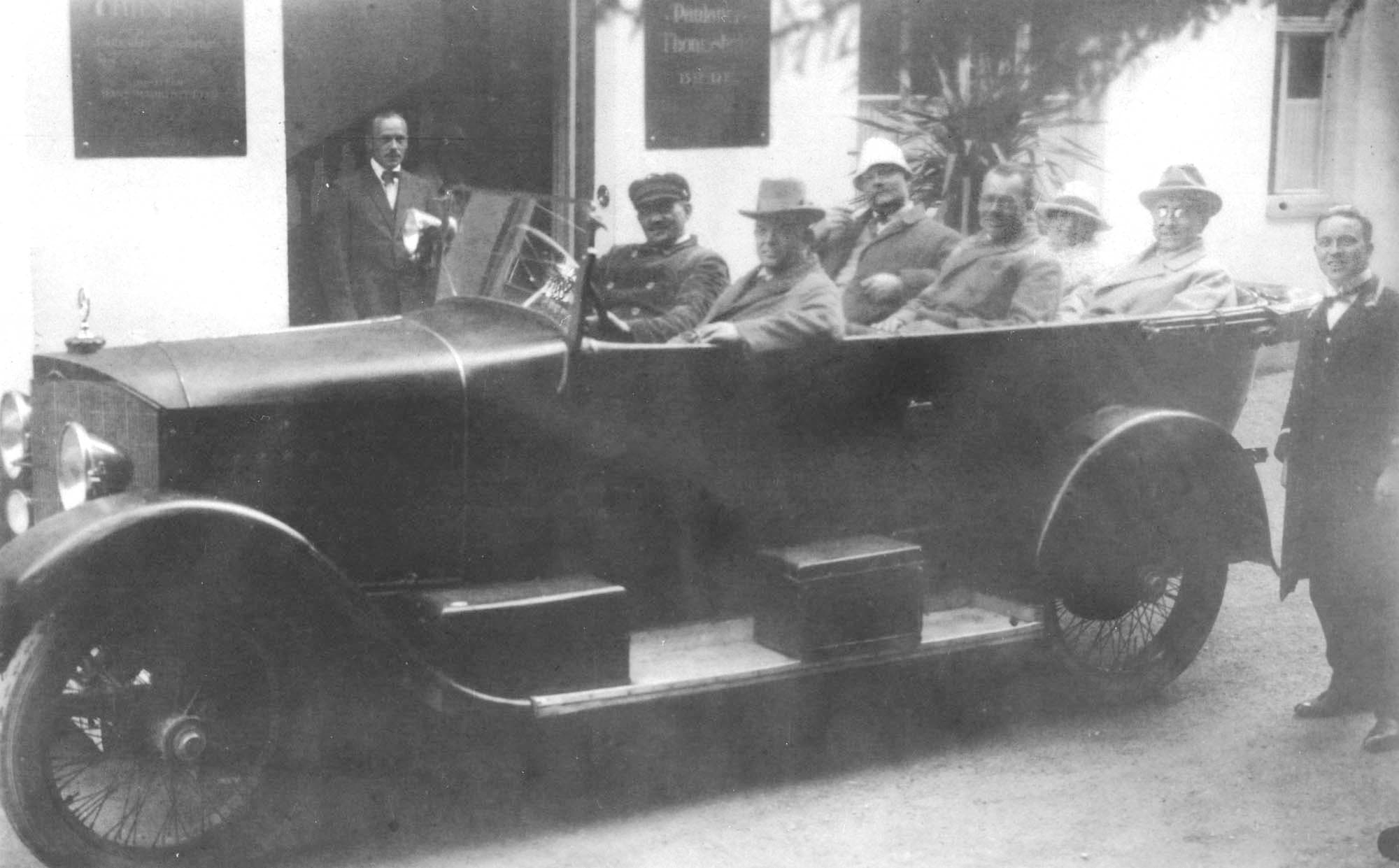 Den udsendte radiofonikommission køreklar foran hotellet i Prien ved Chiemsee. Forrest sidder Carl Nielsen ved siden af chaufføren, i midten Poul Schierbeck (med hvid hat) og overingeniør Kay Christiansen, bagest Katarina og Emil Holm.