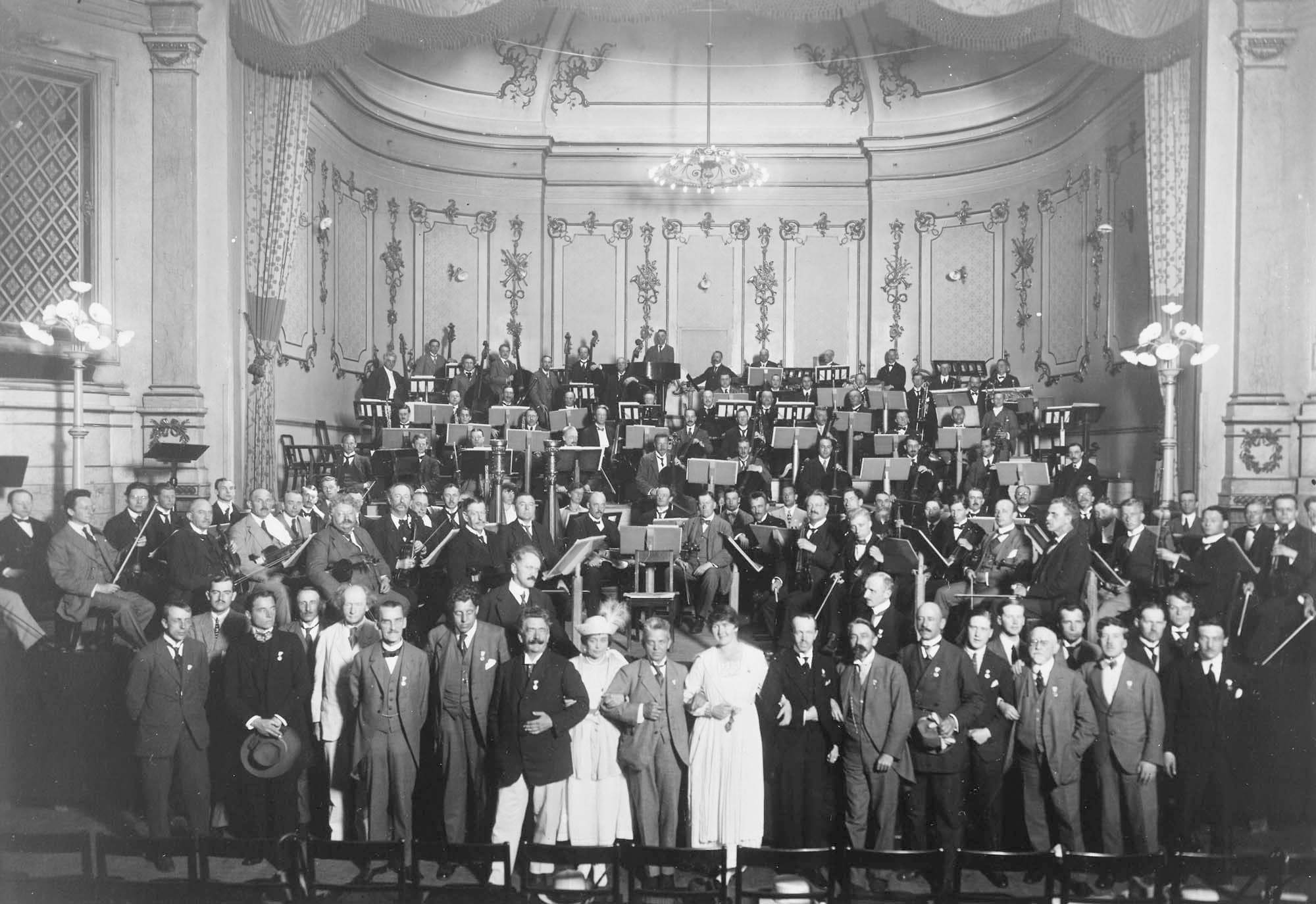 Odd Fellow Palæets store sal, Den Nordiske Musikfest 1919. I forreste række står blandt andre Ture Rangström, Robert Kajanus, Georg Høeberg, Johan Halvorsen, Carl Nielsen, Gunna Breuning-Storm, Erkki Melartin og Fr. Schnedler-Petersen.