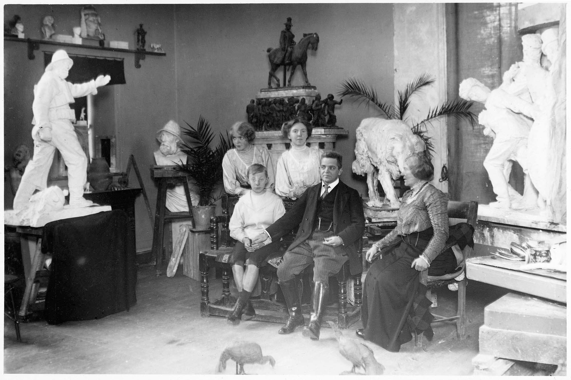 Dette og næste billede: Familien i atelieret omgivet af udkast til detaljer i kongemonumentet. I baggrunden det foretrukne konkurrenceudkast. Vodroffsvej, 1909.